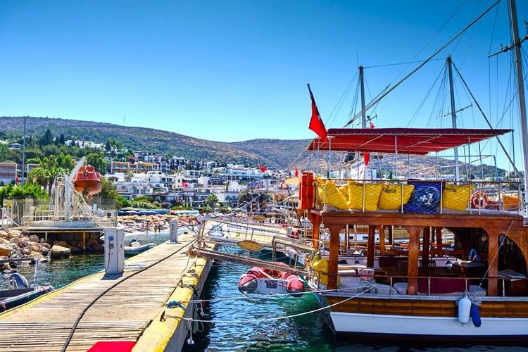 Une goélette en bois typique est amarrée dans la marina