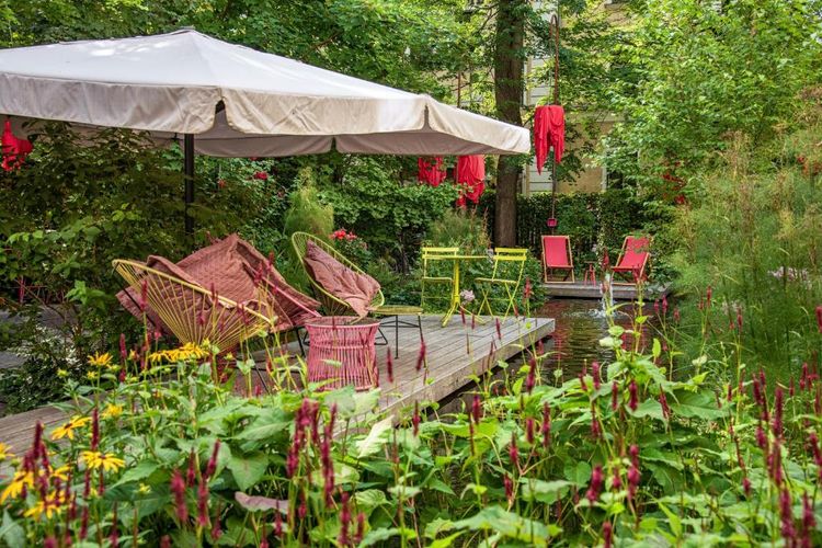 Le jardin fleuri et son point d'eau créant une atmosphère bucolique
