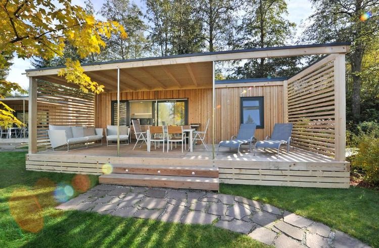 Die Terrasse eines Mobilheims mit Liegestühlen, Esstisch und Sesseln