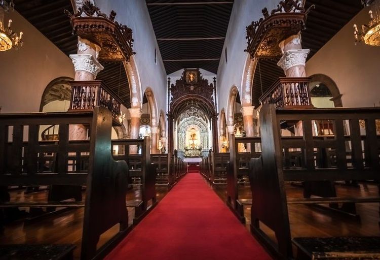 Intérieur de l'église de style baroque et manuélin, mélant bois sombre et teintes claires