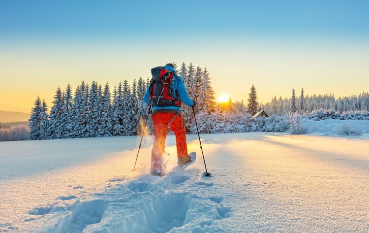 Randonnée hivernale en raquettes au coucher du soleil.