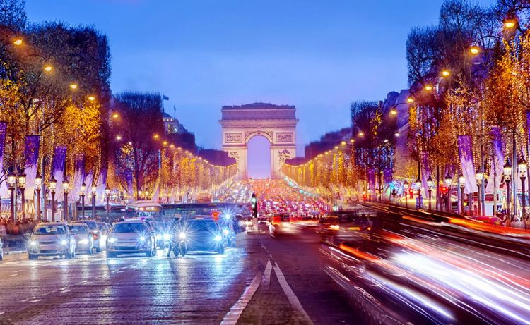 L'avenue des Champs Elysées éclairée, à la nuit tombée.