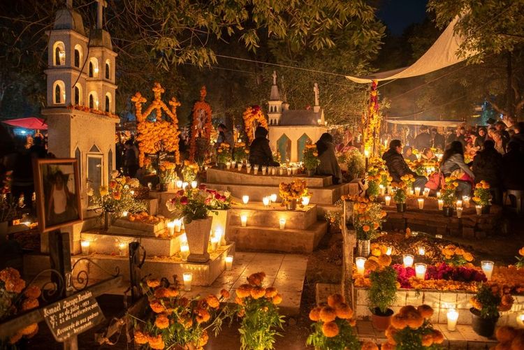 Les tombes éclairées à la bougie et décorées de fleurs de souci pendant el dia de muertos à Michoacan