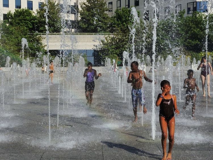 Des enfants jouant sous les jets d'eau du parc André Citroën à Paris