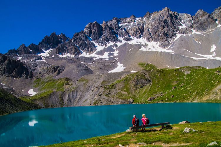 Des randonneurs admirent le Le lac Sainte-Anne dans les Hautes-Alpes