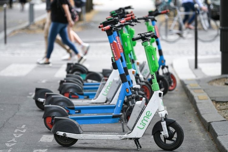 Des trottinettes à l'arrêt sur un trottoir dans Paris