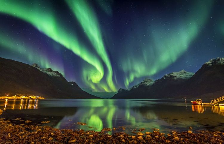 Une aurore boréale d'un vert chatoyant au dessus d'un fjord © Simone Gramegna / Shutterstock