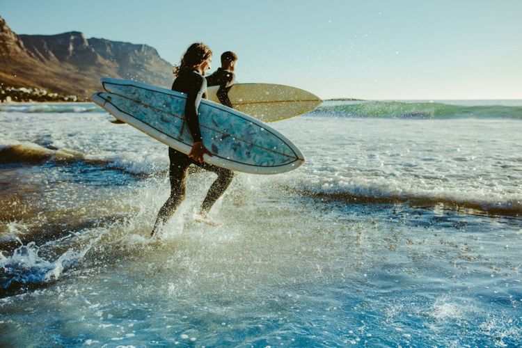 Surfers se jettant à l'eau