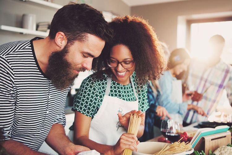 Un jeune couple en plein cours de cuisine