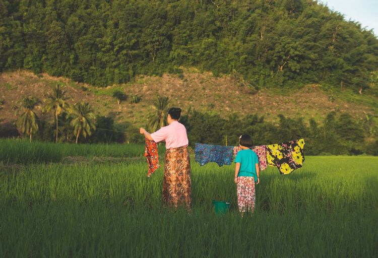 Une mère et sa fille en train d'étendre le linge dans un champs au Vietnam