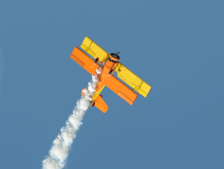 Un biplan dans les airs réalisant de la voltige