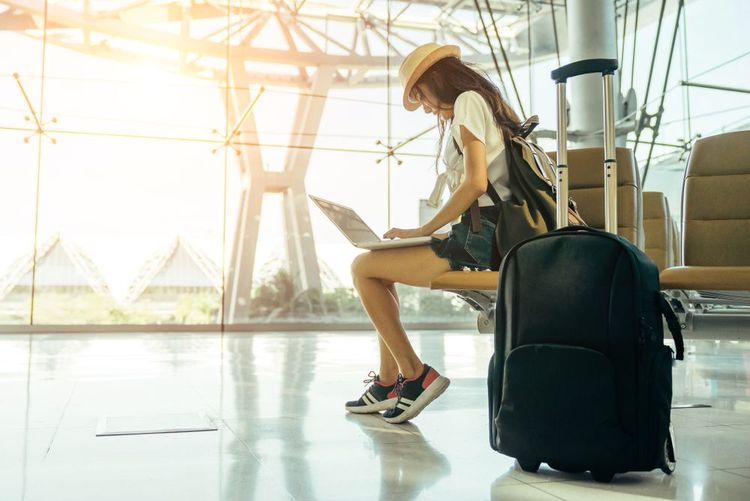 Une personne utilisant son pc portable en attendant son vol dans un aéroport