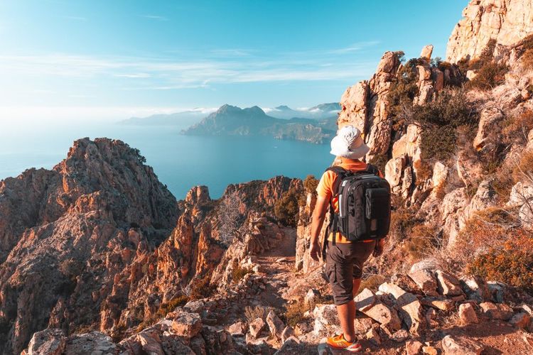 Un randonneur admire la vue sur les calanques de Piana.