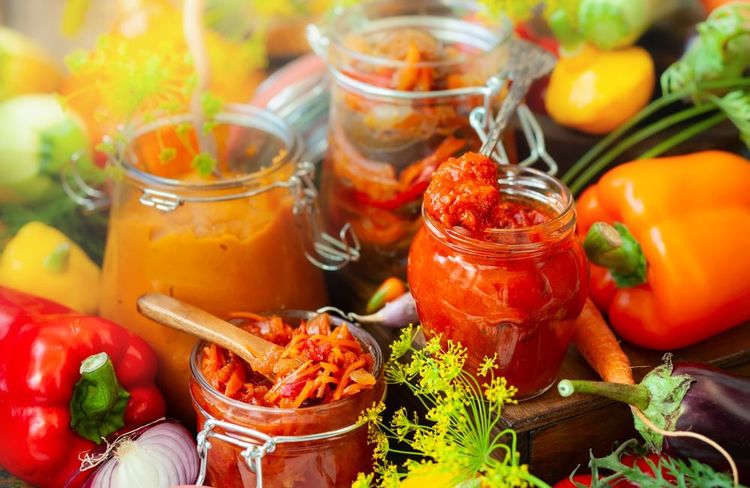 En automne, purée de poivron et d'aubergine (ajvar), caviar de citrouille, ratatouille et carottes marinées sont mis en conserves dans des bocaux.