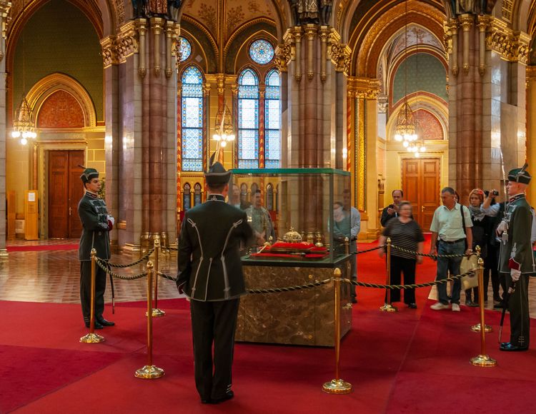 Budapest, Ungarn - 18. September 2010: Präsentation der heiligen Krone Ungarns vor einer Gruppe von Touristen in der zentralen Halle des ungarischen Parlaments. Von einem Ehrengardisten streng bewacht.