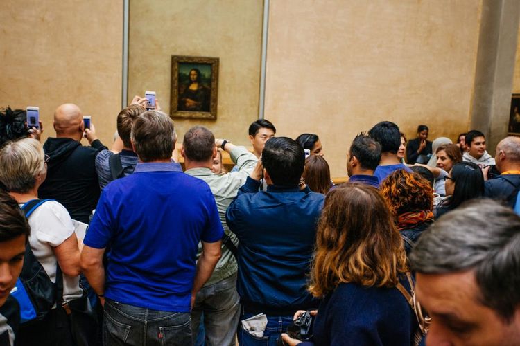 Les visiteurs admirent le tableau de La Joconde, au musée du Louvre, à Paris.