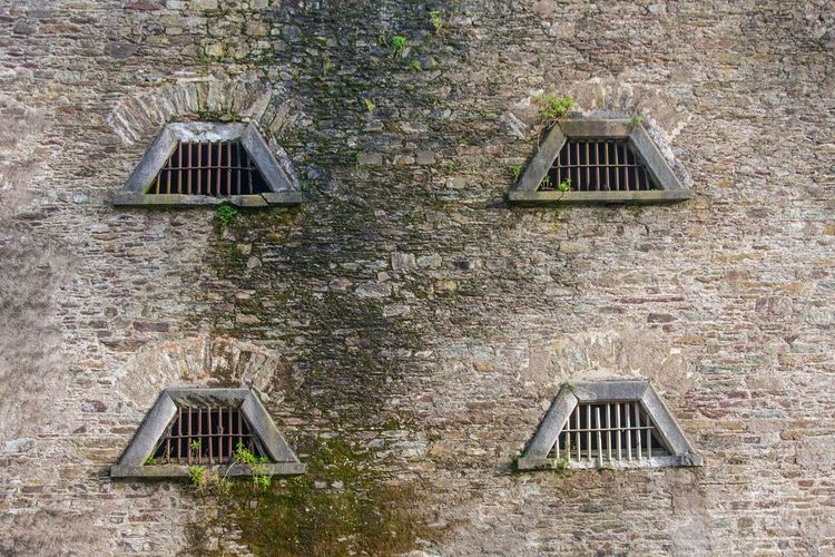 Fenêtres étroites et barrées de barreaux des cachots