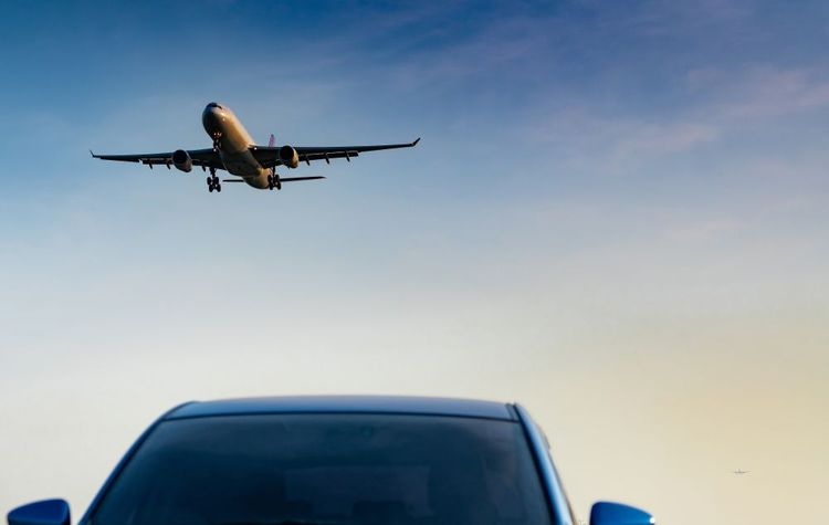 Un avion survolant une voiture.