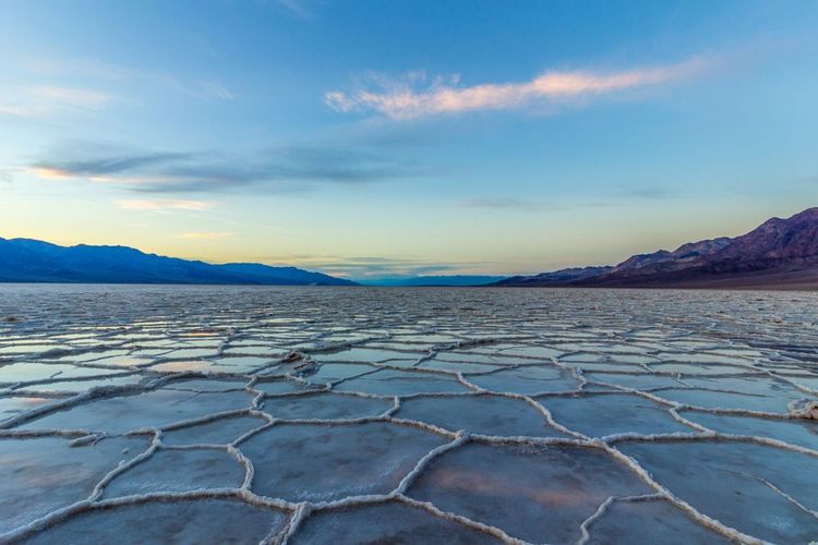 Bassin de Badwater au coucher du soleil. Réflexion de la croûte de sel et des nuages. Parc national de la vallée de la Mort. Californie, États-Unis