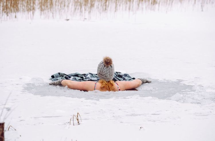 Une femme se baigne dans une eau gelée.