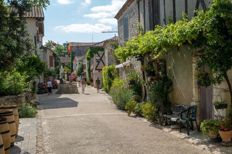 La rue principale de Pujol avec ses maisons anciennes et les plantes grimpantes.