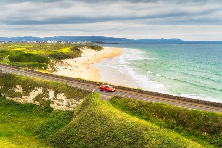 Une voiture de sport rouge emprunte le Wild Atlantic Way.