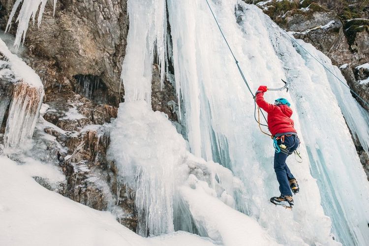 Un alpiniste en train de gravir une cascade de glace.