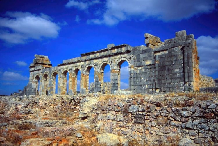 Les ruines de la basilique (à dr.) et les arcades de la tribune aux harangues du forum