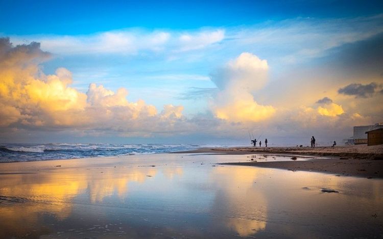 Des gens pêchent au crépuscule sur la plage de Bou Jaafar sur la mer Méditerranée à Sousse, Tunisie.