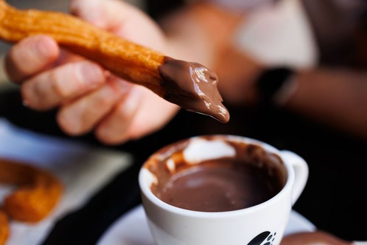 L'espagnol churros trempé dans un chocolat chaud bien épais