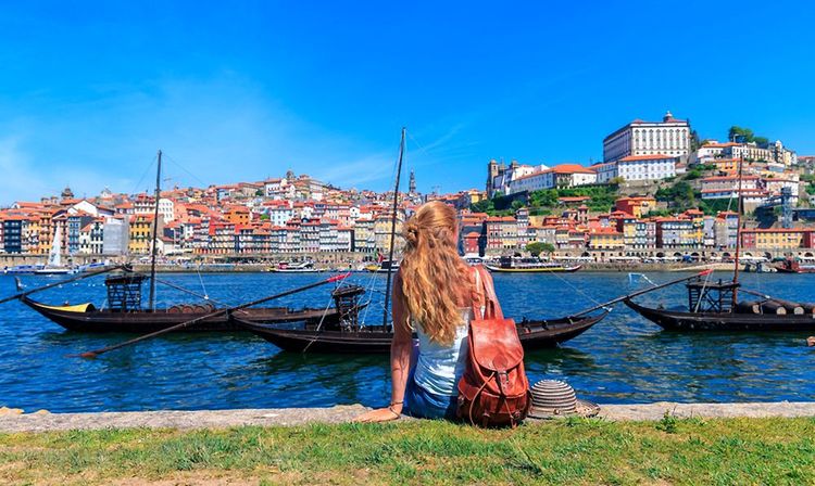 Jeune femme assise sur les quais de Porto