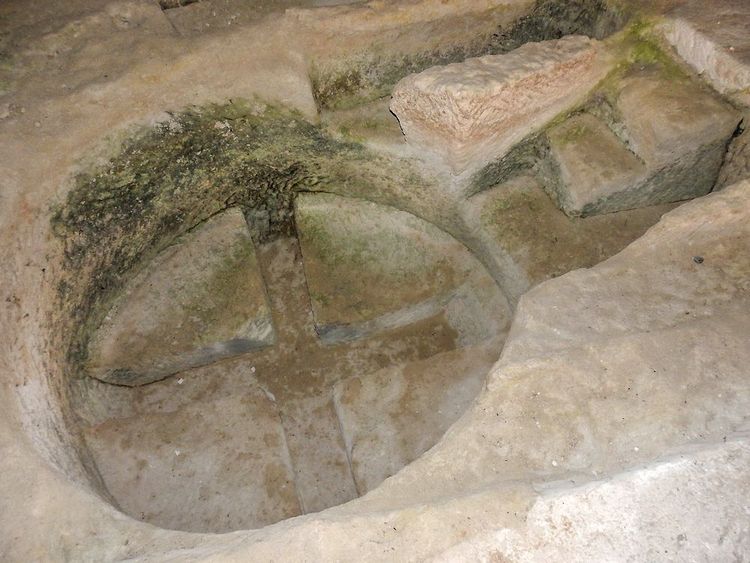 Le font baptismal en pierre (cuve pour les baptèmes), creusé d'une croix