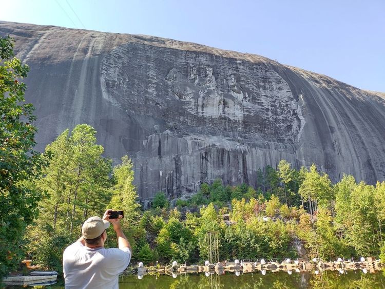 Un touriste photographie Stone Mountain.