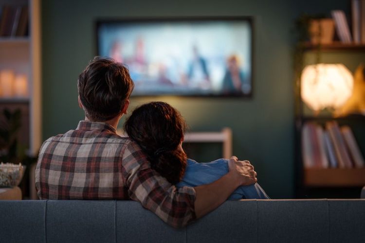 Un couple regarde un film à la télé.