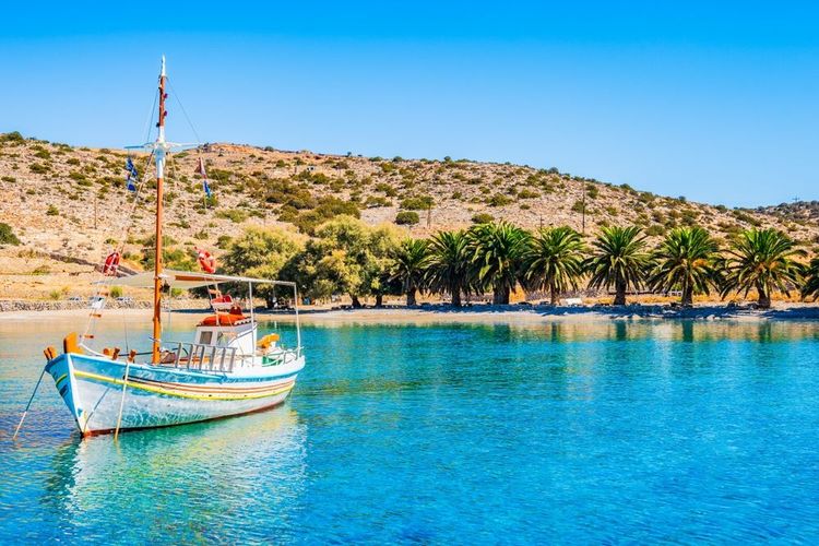 Bateau de pêche sur mer azur et palmiers sur la plage idyllique de Panormos, île de Naxos
