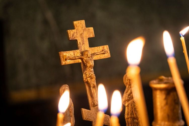 Les bougies votives dans la cathédrale proches d'un crucifix portant Jésus 