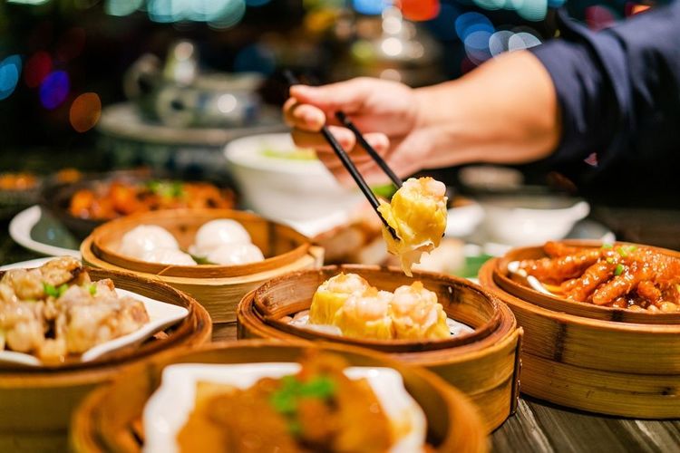 On picore des dim sum (raviolis chinois) pendant un repas sous forme de buffet de paniers vapeur en bambou
