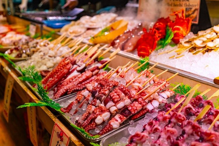 Chez le poissonnier, brochettes de tentacules de poulpe, à déguster sur place ou à emporter