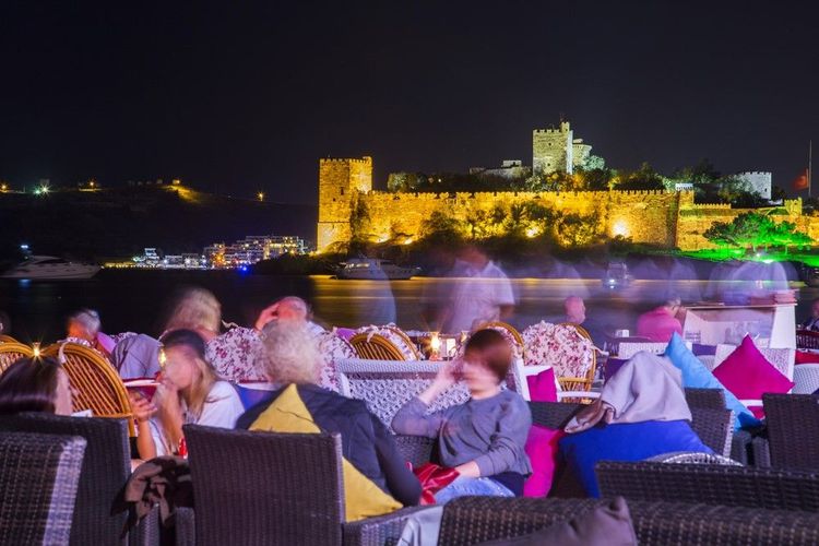 Prendre un verre sur la marina, le soir, avec le chateau St-Pierre en décor