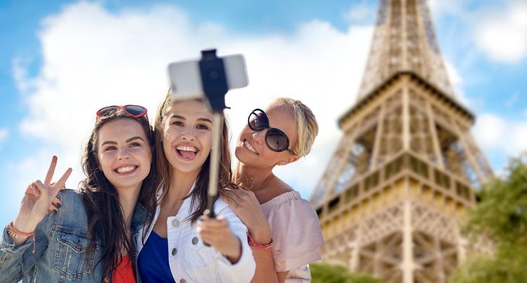 Trois amis se prenant en photo avec une perche à selfie.