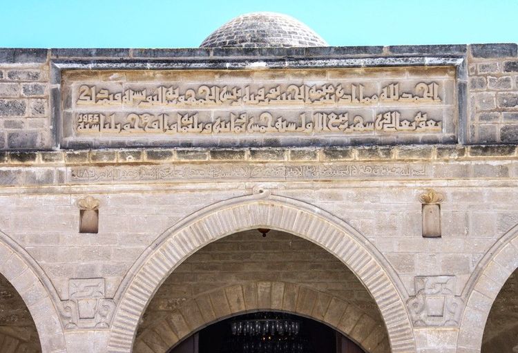 Des inscriptions coufiques sont gravées sur la frise surplombant la galerie voûtée