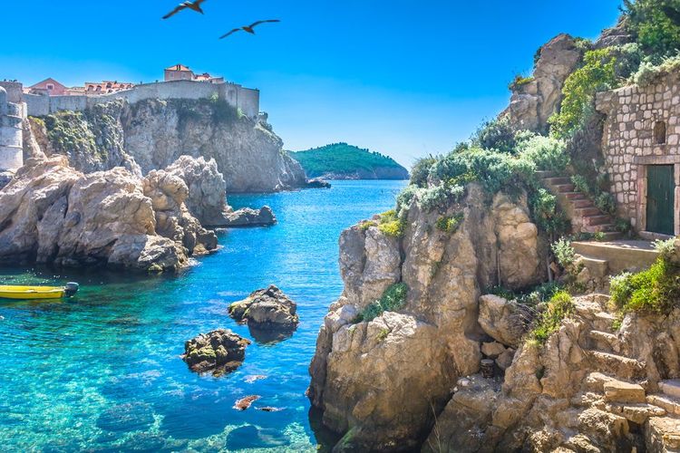 Escaliers creusés dans la roche, à Dubrovnik. L'île de lokrum au fond.