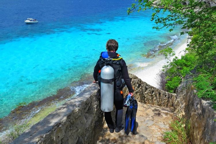 Un plnogeur descend vers une plage sarde avant de plonger