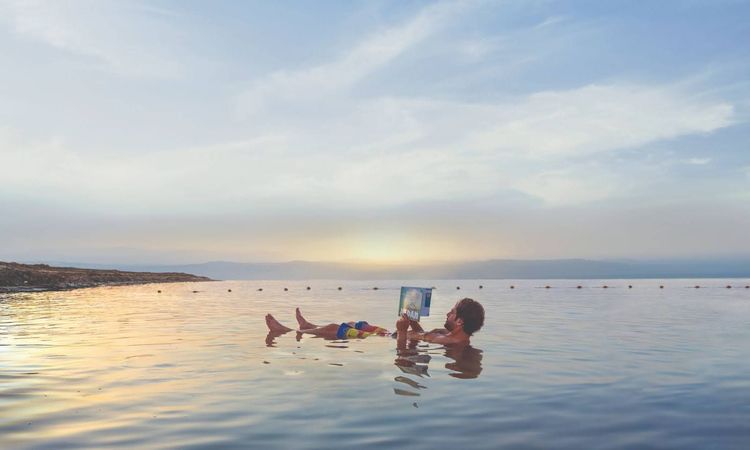 Un homme flottant dans la mer Morte en Jordanie / Jordan Tourism Board